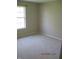 A light filled bedroom with neutral walls, carpet, and a large window at 533 Charnwood Pkwy, Beech Grove, IN 46107
