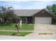 Charming single-story brick home with a two-car garage, green lawn and mature landscaping at 533 Charnwood Pkwy, Beech Grove, IN 46107