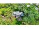 Aerial view of the property showcasing a large backyard, deck, garden beds, and surrounding mature trees at 5840 Brouse Ave, Indianapolis, IN 46220