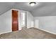 Attic bedroom with neutral carpet and a dark wooden door at 5840 Brouse Ave, Indianapolis, IN 46220