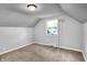 Attic bedroom with neutral carpet, window and sloping ceiling at 5840 Brouse Ave, Indianapolis, IN 46220
