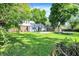 Large backyard with lush green lawn, garden beds, and a deck, ideal for outdoor activities and relaxation at 5840 Brouse Ave, Indianapolis, IN 46220