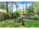 Secluded backyard with mature trees, garden beds, and a brick-lined feature, offering a private outdoor space at 5840 Brouse Ave, Indianapolis, IN 46220