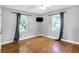 Bedroom with hardwood floors, two windows with curtains, and a wall-mounted TV at 5840 Brouse Ave, Indianapolis, IN 46220