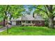 Charming brick home featuring a well-maintained lawn and lush green trees at 5840 Brouse Ave, Indianapolis, IN 46220