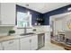 Well-lit kitchen with white cabinets, stainless steel appliances, and a view of the dining area at 5840 Brouse Ave, Indianapolis, IN 46220