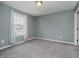 A cozy bedroom featuring a window with curtains, neutral walls, and plush gray carpeting at 6101 Hardwick Dr, Whitestown, IN 46075