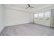 Bright bedroom featuring neutral colors, carpet, a ceiling fan, and large windows with neighborhood views at 6101 Hardwick Dr, Whitestown, IN 46075