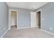 An inviting bedroom boasts neutral paint, closet, carpet, and two entryways to other rooms at 6101 Hardwick Dr, Whitestown, IN 46075