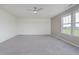 Spacious bedroom featuring neutral walls, carpet, a ceiling fan, and large windows with neighborhood views at 6101 Hardwick Dr, Whitestown, IN 46075