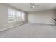 Bright bedroom featuring neutral colors, carpet, large windows with neighborhood views, and a ceiling fan at 6101 Hardwick Dr, Whitestown, IN 46075