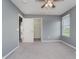 Bedroom with neutral carpet, gray walls, ceiling fan, window, and walk-in closet at 6101 Hardwick Dr, Whitestown, IN 46075