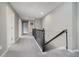 Upstairs hallway with neutral walls, carpet, and white doors and dark colored railings at 6101 Hardwick Dr, Whitestown, IN 46075