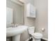 Powder room with stylish pedestal sink, toilet, dark floors, and a decorative mirror at 6101 Hardwick Dr, Whitestown, IN 46075