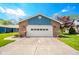 Charming home exterior showcasing a brick garage with a white door and well-manicured lawn at 618 N Buckingham Ct, Anderson, IN 46013