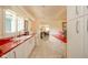 Eat-in kitchen featuring white cabinets, red countertops, and views into a bright living space at 618 N Buckingham Ct, Anderson, IN 46013