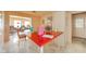 Eat-in kitchen featuring white cabinets, a red countertop island, and views into a bright living space at 618 N Buckingham Ct, Anderson, IN 46013