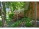 Back deck offering a view of the lush backyard with mature trees, and wooden stairs to a small deck below at 6334 Teak Ct, Indianapolis, IN 46217