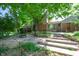 Backyard with a fire pit area, tiered landscaping, and mature trees providing ample shade and privacy at 6334 Teak Ct, Indianapolis, IN 46217