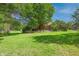 View of the backyard featuring mature trees, a lawn, and the rear of the home at 6334 Teak Ct, Indianapolis, IN 46217