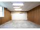 Unfinished basement with damaged ceiling, paneled wall, and the word 