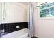 Bathroom with a shower/tub combination and a black and white tile backsplash and shower curtain at 6334 Teak Ct, Indianapolis, IN 46217