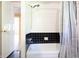 Bathroom with a shower/tub combination and a black and white tile backsplash and shower curtain at 6334 Teak Ct, Indianapolis, IN 46217