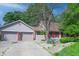 A view of the home with a spacious driveway and attached garage, complemented by neat landscaping and colorful shutters at 6334 Teak Ct, Indianapolis, IN 46217