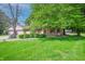 Charming single story home featuring a well manicured lawn, cozy curb appeal, and lovely red shutters at 6334 Teak Ct, Indianapolis, IN 46217