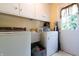 The laundry room features bright white cabinets, modern washer and dryer units, and a sink at 6334 Teak Ct, Indianapolis, IN 46217