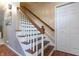 A classic staircase featuring hardwood steps and white risers, complemented by a wooden handrail at 6334 Teak Ct, Indianapolis, IN 46217