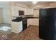 Modern kitchen featuring white cabinets, black appliances, and stylish flooring, perfect for cooking at 706 Alexander St, Greenwood, IN 46143