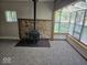 Bright and inviting living room featuring wood burning stove, stone accent, and large windows at 706 Alexander St, Greenwood, IN 46143