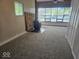 Cozy living room with large windows, wood burning stove, stone accent, and new carpeting at 706 Alexander St, Greenwood, IN 46143