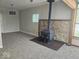 Inviting living area featuring wood-burning stove, stone surround, new carpet, and a ceiling fan at 706 Alexander St, Greenwood, IN 46143
