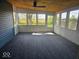 The sun room has multiple large windows and carpeted floor at 706 Alexander St, Greenwood, IN 46143