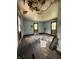 Spacious bedroom requiring restoration, featuring hardwood floors and three windows at 715 S Anderson St, Elwood, IN 46036