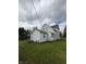 View of home featuring light colored siding and a well-maintained green lawn at 715 S Anderson St, Elwood, IN 46036