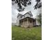 Two-story home with a covered porch, surrounded by a green lawn at 715 S Anderson St, Elwood, IN 46036