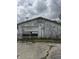 Detached garage with peeling paint and a partially open door at 715 S Anderson St, Elwood, IN 46036