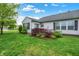 Landscaped backyard with green grass, patio area, and vibrant bushes and plants, ideal for outdoor enjoyment at 7156 Chemistry Ct, Indianapolis, IN 46239