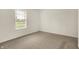 Simple carpeted bedroom with a window showing exterior view and natural light at 7156 Chemistry Ct, Indianapolis, IN 46239