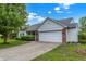 Side view of a home, featuring a brick-accented garage, well-kept lawn, and a concrete driveway at 7156 Chemistry Ct, Indianapolis, IN 46239