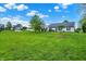 Expansive lawn surrounds a charming single-story home, showcasing its curb appeal in a tranquil neighborhood setting at 7156 Chemistry Ct, Indianapolis, IN 46239