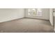 An airy room with neutral carpeting and white walls, complemented by natural light from large windows at 7156 Chemistry Ct, Indianapolis, IN 46239