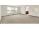 An open and spacious living area with gray carpeting, white walls, and large windows at 7156 Chemistry Ct, Indianapolis, IN 46239