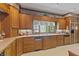 Kitchen featuring wood cabinets, ample counter space, and a window overlooking the lush exterior at 7400 Oakbay Dr, Noblesville, IN 46062