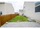 A quaint, grassy backyard featuring a wood fence, gravel area, and side access to the home at 7632 Nestucca Trl, Noblesville, IN 46062