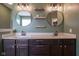 Bathroom vanity with dual sinks, granite counters, decorative lighting, and floating shelves at 7632 Nestucca Trl, Noblesville, IN 46062
