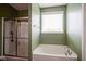 This bathroom features a soaking tub under a window and a glass-enclosed shower with a modern shower head at 7632 Nestucca Trl, Noblesville, IN 46062